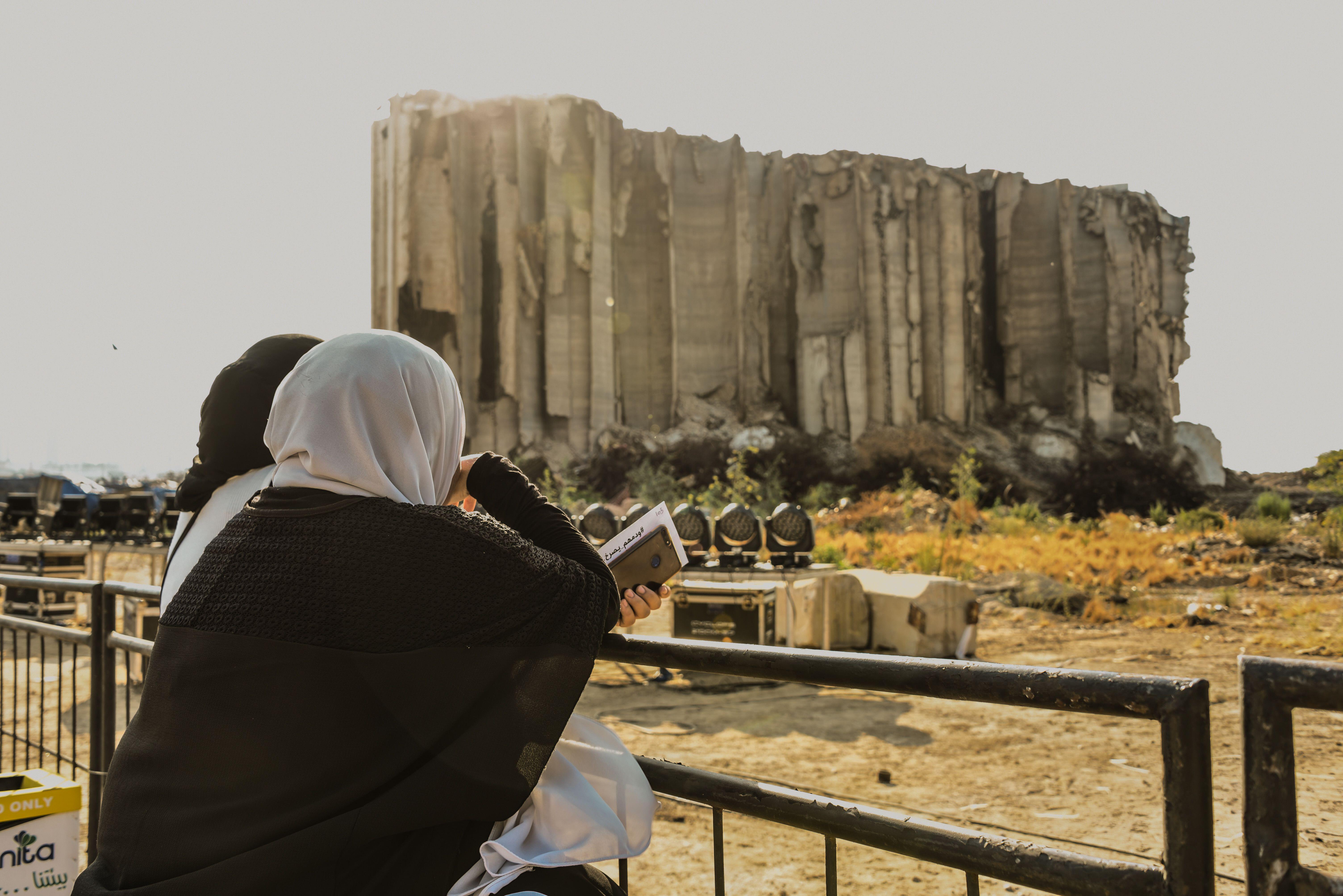 Beirut, Lebanon, 4 August 2021. Relatives of people killed in the Beirut Blast stand in front of a now iconic grain silo destroyed in the explosion, contemplating the spot where it happened on the one year anniversary of one of the largest non-nuclear exp